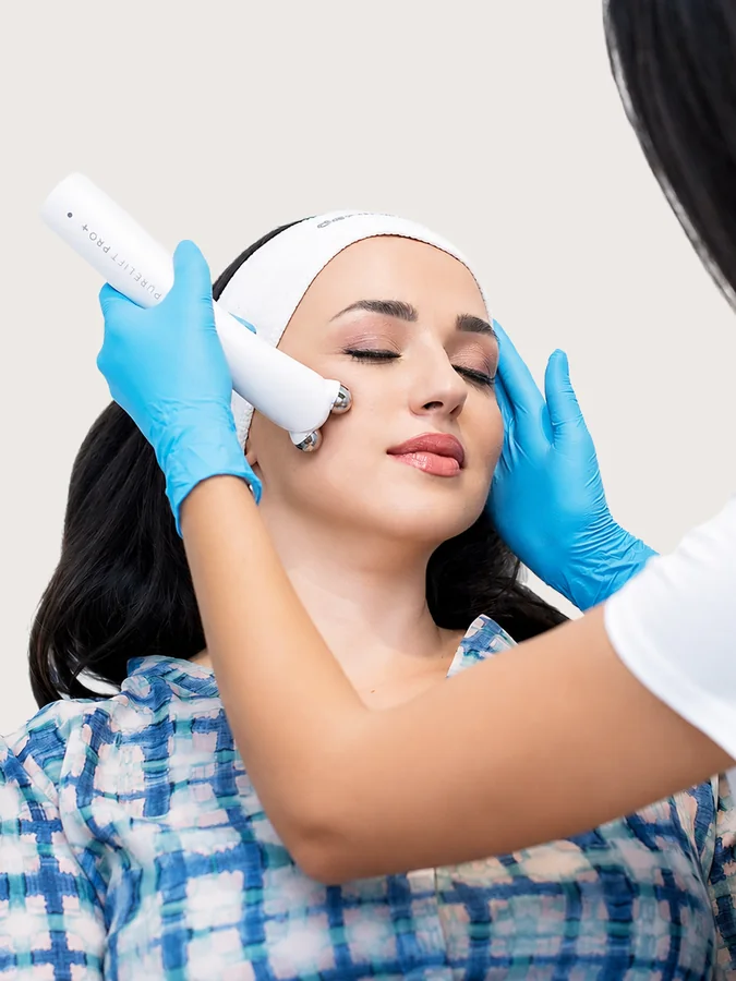 Practitioner using PureLift Pro Plus on a client&rsquo;s cheek